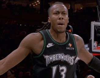 Man In Timberwolves Jersey In Front Of Tissot Scoreboard GIF