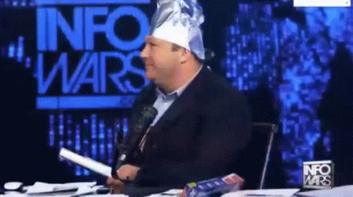 Man In Tin Foil Hat In Front Of InfoWars Sign GIF