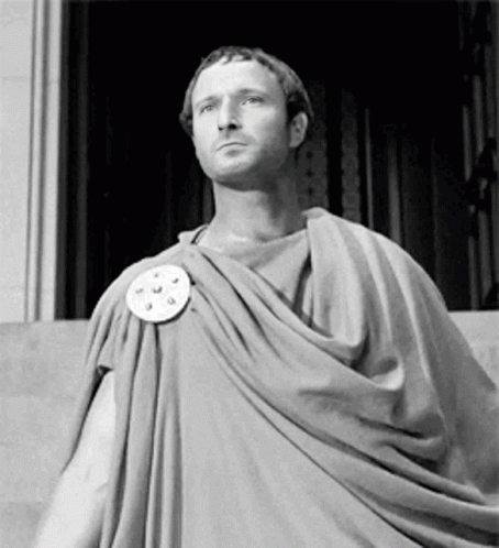 Man in Toga Standing in Front of Building