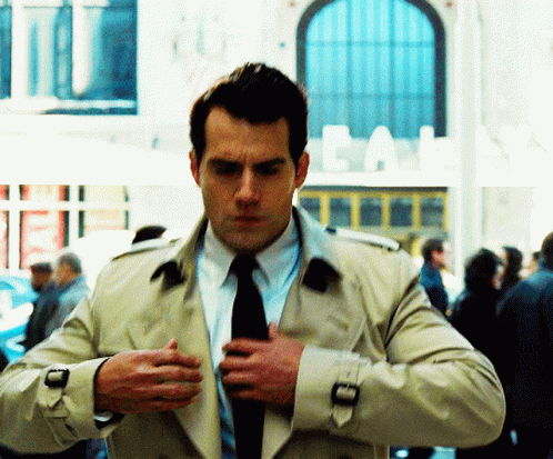 Man in Trench Coat and Tie in Front of Cal Building