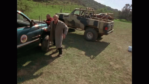Man in Trench Coat Next to Sierra Truck