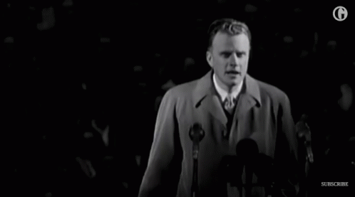 Man In Trench Coat Speaking Into Microphone GIF
