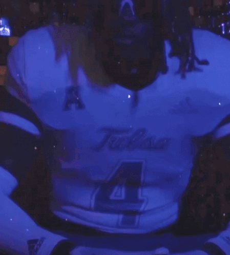 Man in Tulsa Jersey Standing in Front of Purple Background