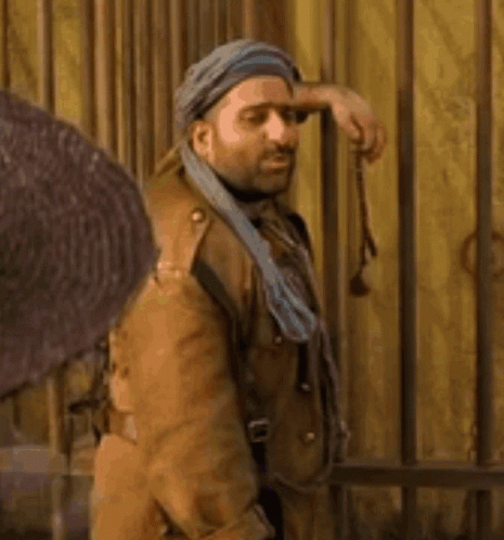 Man in Turban and Brown Coat Holding Gun