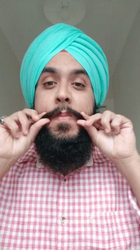 Man In Turban And Checkered Shirt Holding Mustache GIF