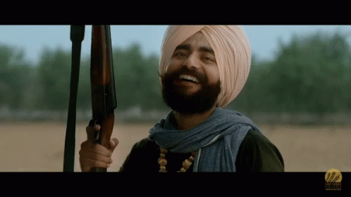 Man In Turban Holding Gun Smiling GIF
