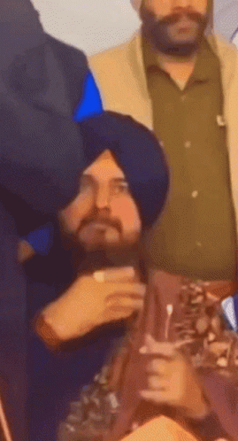 Man in Turban Sitting in Crowd