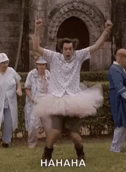 Man in Tutu Dancing in Field With Group