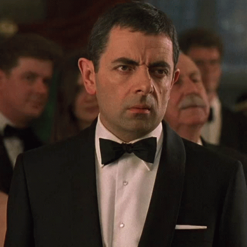 Man In Tuxedo And Bow Tie Looks At Camera GIF