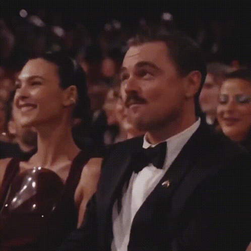 Man in Tuxedo and Bow Tie Sitting Next to Woman