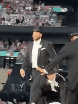 Man in Tuxedo and Top Hat Dancing Before Crowd