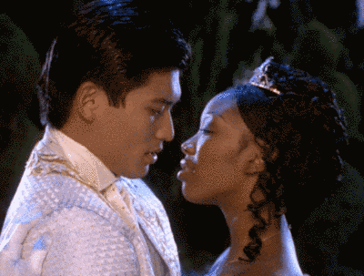 Man In Tuxedo And Woman In Tiara Kissing GIF