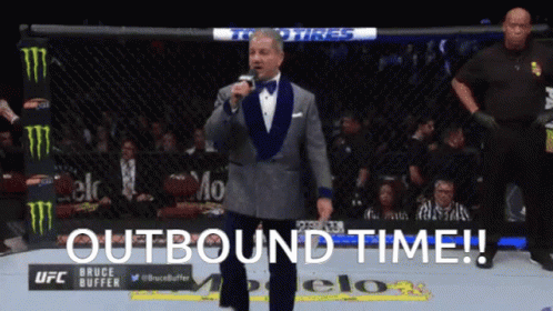 Man in Tuxedo at Microphone with Outbound Time
