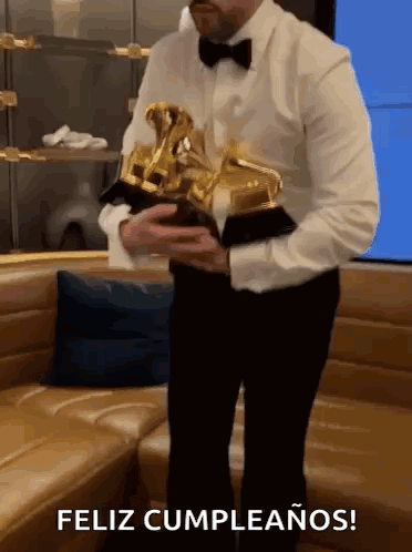 Man in Tuxedo Holding Trophy Feliz Cumpleanos