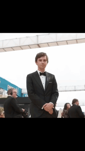 Man in Tuxedo in Front of Pepsi Sign