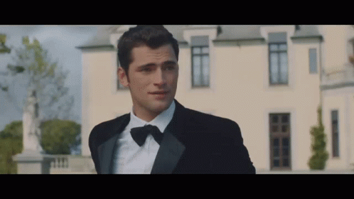 Man in Tuxedo in Front of White Building
