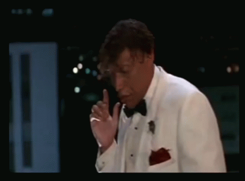 Man in Tuxedo Smoking Cigarette in Dark Room