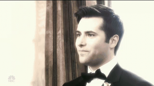 Man in Tuxedo Standing in Front of Window With NBC Logo