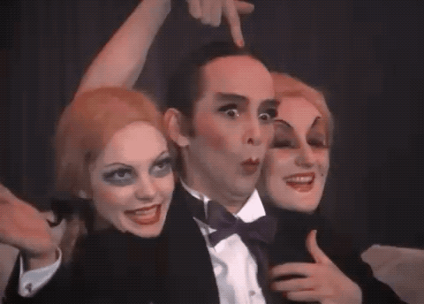 Man in Tuxedo Surrounded by Two Women With Makeup