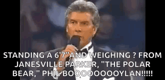Man In Tuxedo Talking At Microphone GIF