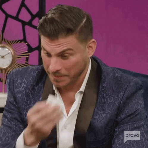Man in Tuxedo Wiping Face With Bravo Logo