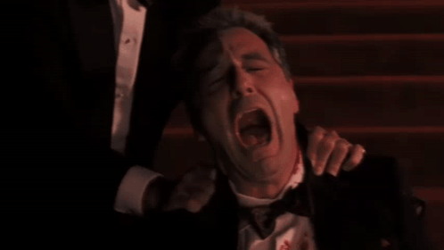 Man in Tuxedo with Blood Being Held