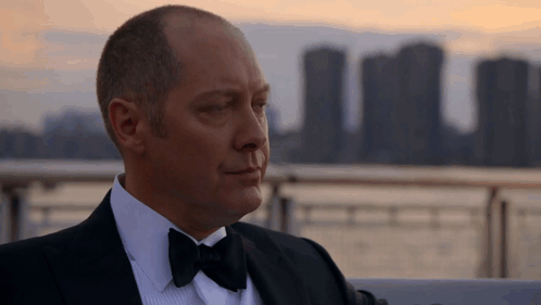 Man In Tuxedo With Bow Tie Looking At Camera GIF