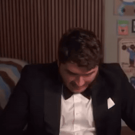 Man in Tuxedo with Bow Tie Sitting on Bed