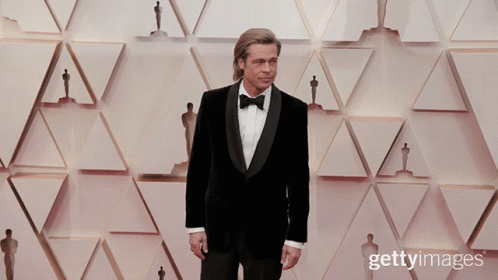 Man in Tuxedo With Oscar Statues