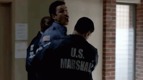 Man In U.S. Marshal Jacket Being Escorted GIF