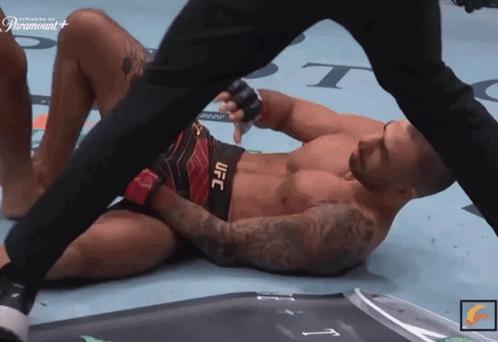 Man in UFC Shorts Laying on Floor