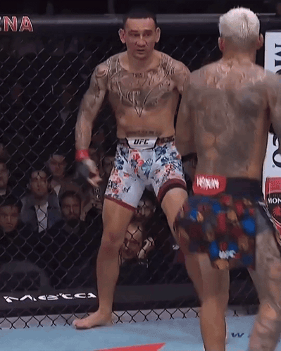 Man in UFC Shorts Next to Man in Boxing Ring