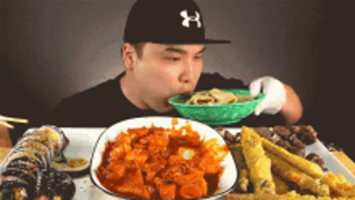 Man in Under Armour Hat Eating Noodles