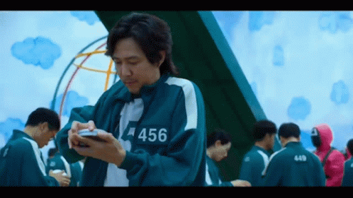 Man in Uniform with 456 Looking at Phone