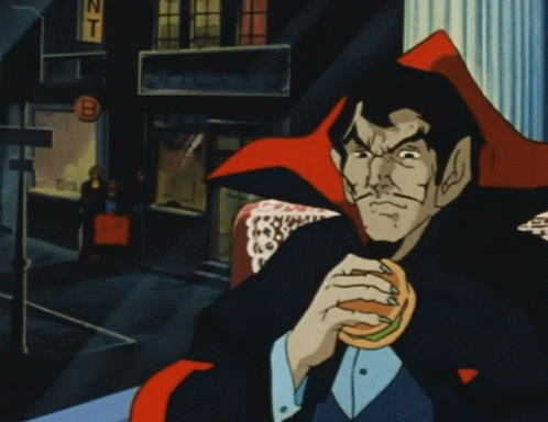 Man in Vampire Costume Eating Hamburger