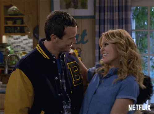 Man in Varsity Jacket with B Hugging Woman