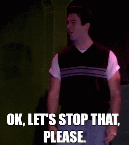 Man in Vest on Stage Saying Ok Let's Stop That Please