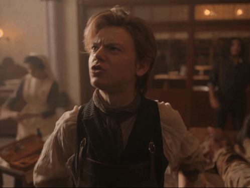 Man In Vest With Woman In White Dress Behind Him GIF