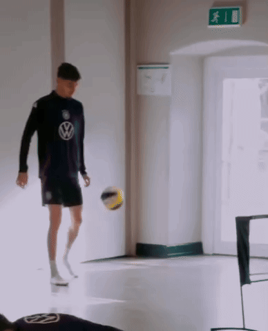 Man in Volkswagen Shirt Kicking Ball