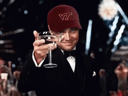 Man in VT Hat Holding Glass of Wine