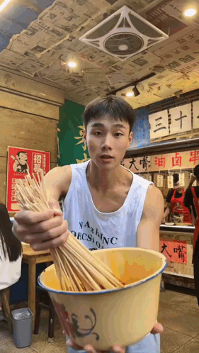 Man in Washington Tank Top Holding Bowl of Sticks