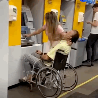 Man In Wheelchair Helped By Woman At ATM GIF