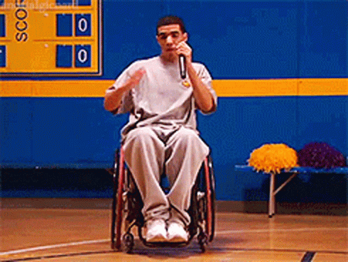 Man in Wheelchair Speaking Into Microphone