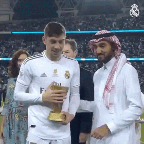 Man in White Adidas Shirt Holding Trophy