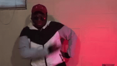 Man in White and Black Jacket Dancing in Red Lights