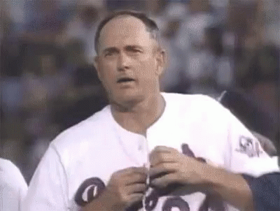 Man in White Baseball Uniform Holding Pen