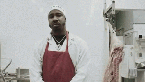 Man in White Coat and Red Apron with Meat