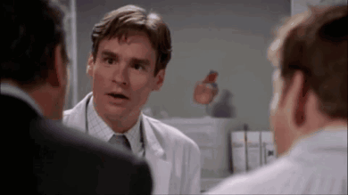 Man In White Coat Talking To Two Men GIF