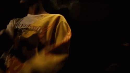Man in White Coca Cola Shirt in Dark Room
