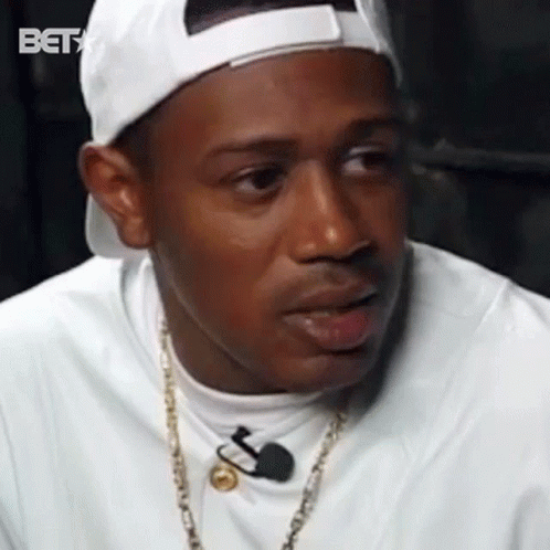 Man In White Hat And Gold Chain Talking To Microphone GIF